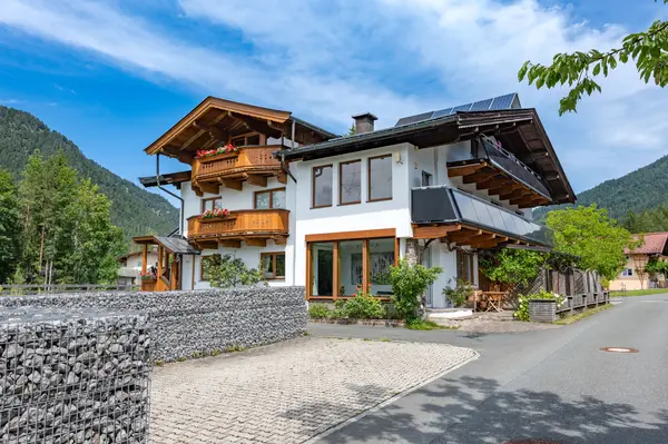 Haus von außen mit Garten und Bergblick